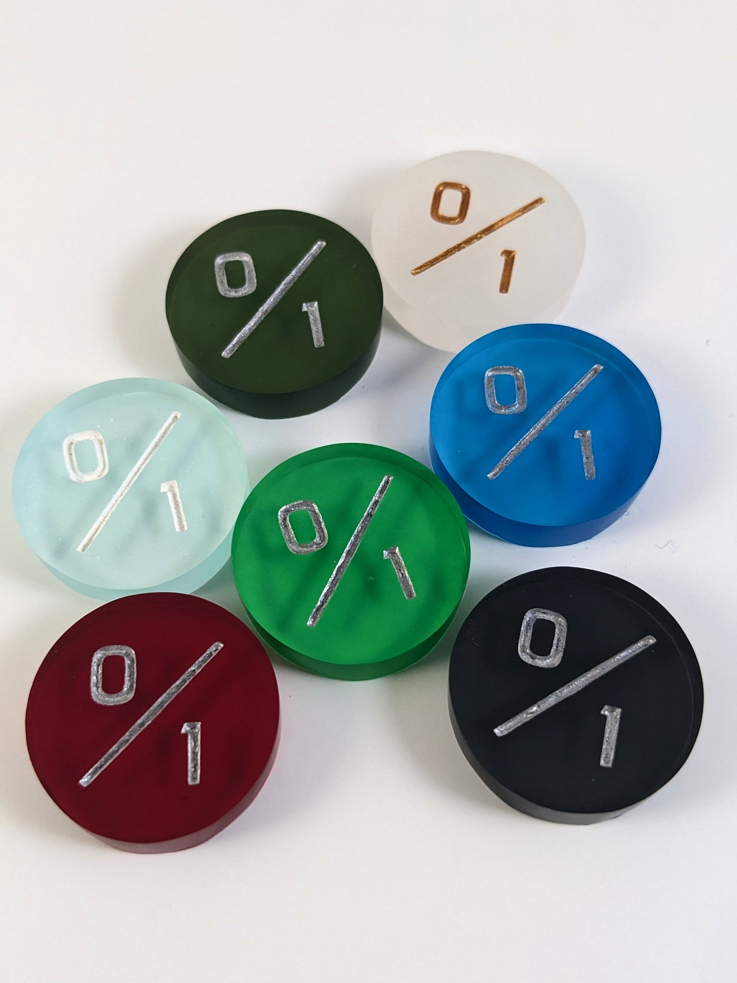 A collection of 0/1 tokens in a variety of colors on a white background. Each token is face up.