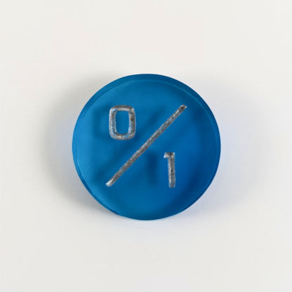 A top down photo of a blue 0/1 token with silver numbers sits on a white background.
