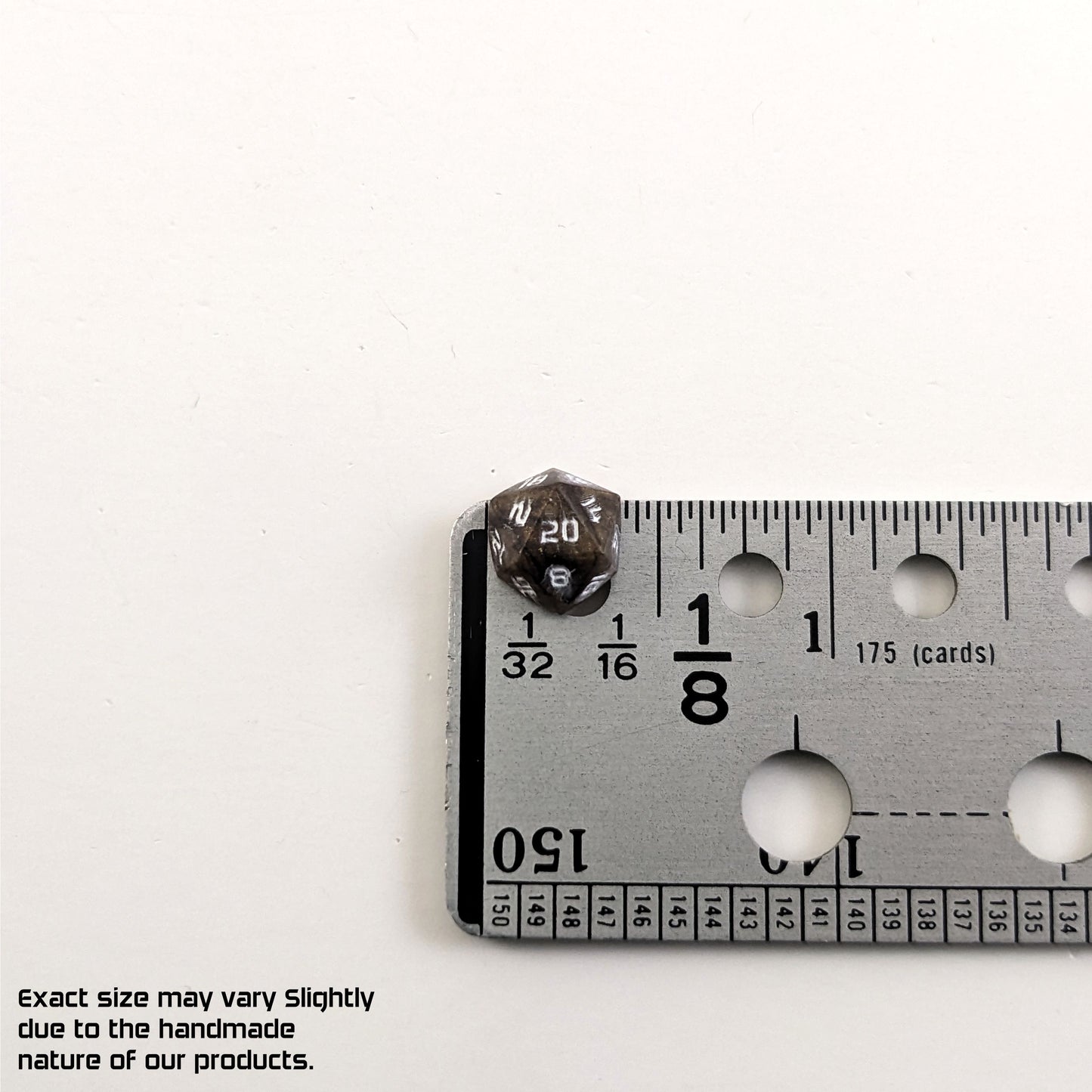 A size graphic of the d20 stud. The stud is brown with white numbers and centers the 20 face next to a ruler on a white background. The ruler shows the width of the stud as 10 mm or 0.39 in. The lower lefthand corner has a disclaimer that reads, "Exact size may vary slightly due to the handmade nature of our products."