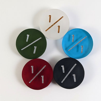 Five 1/1 tokens arranged in a circle face up. White with gold numbers is at the top and blue, black, red, and dark green all with silver numbers follow going clockwise.