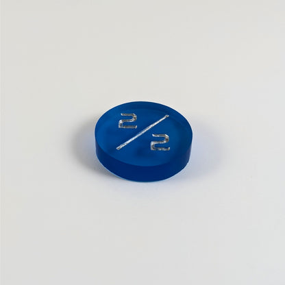 A low angle photo of a blue 2/2 token with silver numbers sits on a white background.