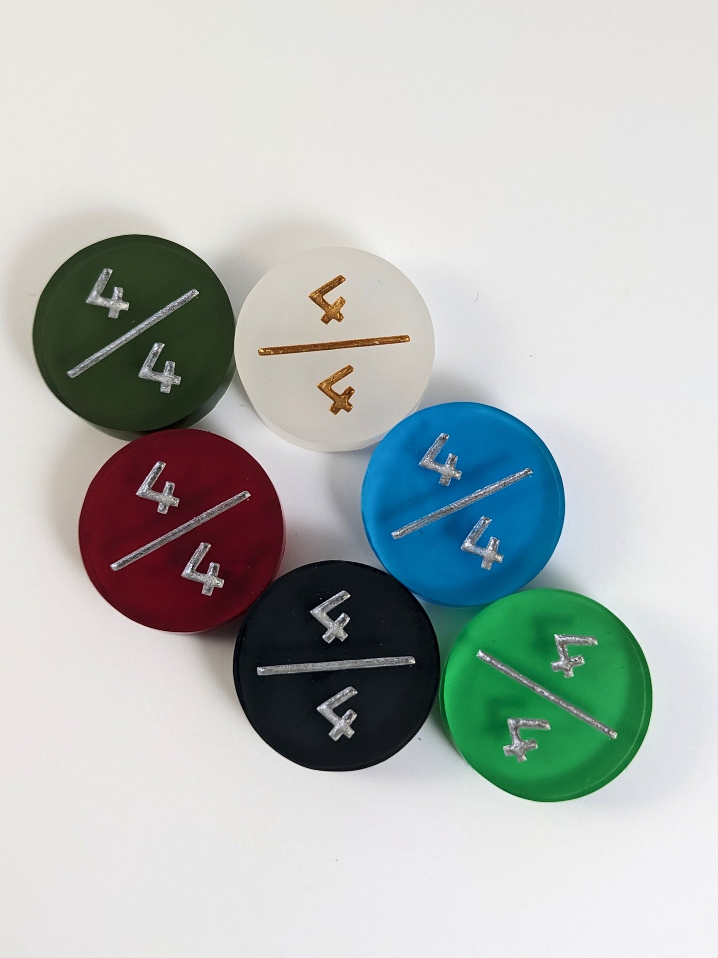 A collection of 4/4 tokens in a variety of colors on a white background. Each token is face up.