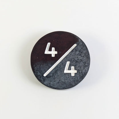 A top down photo of a silver and maroon 4/4 token with white numbers sits on a white background. The cosmetic flaw is not visible due to the opacity of the token.