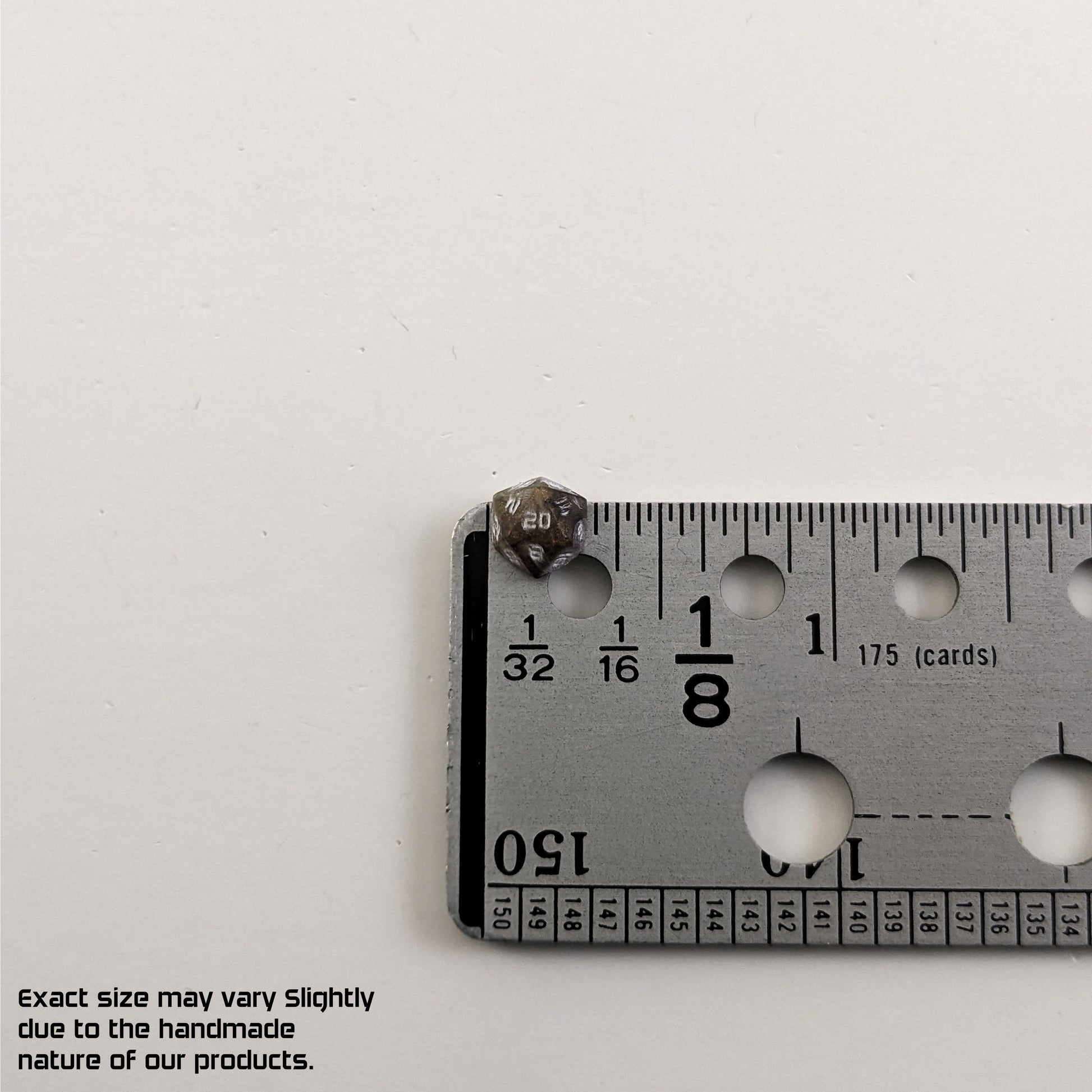 A size graphic of the d20 stud. The stud is brown with white numbers and centers the 20 face next to a ruler on a white background. The ruler shows the width of the stud as 7 mm or 0.27 in. The lower lefthand corner has a disclaimer that reads, "Exact size may vary slightly due to the handmade nature of our products."