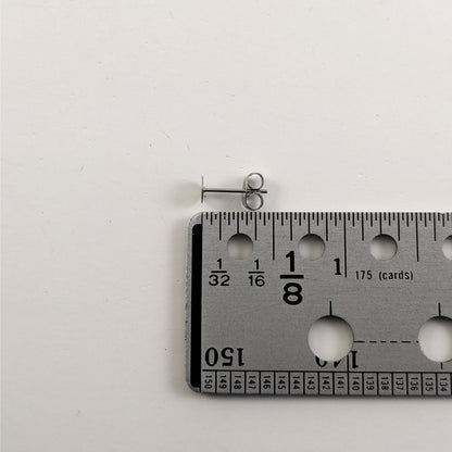 A size graphic of an earring post and butterfly back next to a ruler and on a white background. It shows the length of the post as 12 mm or 0.47 in.
