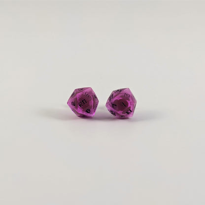 A single pair of the larger size handmade d20 earrings with titanium hardware that are amethyst purple with black numbers on a white background. The earring on the left centers the 20 face and the earring on the right centers the 1 face.