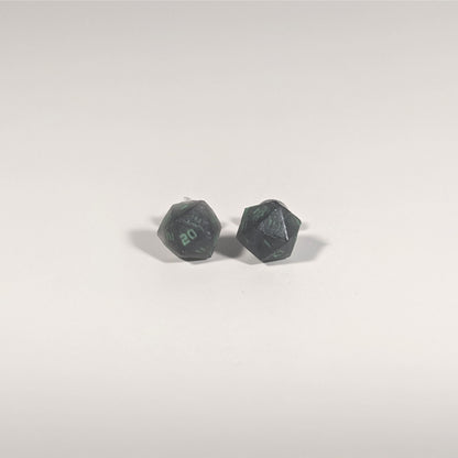 A single pair of the smaller size handmade d20 earrings with titanium hardware that are black with a touch of silver with acidic green numbers on a white background. The earring on the left centers the 20 face and the earring on the right centers the 1 face.