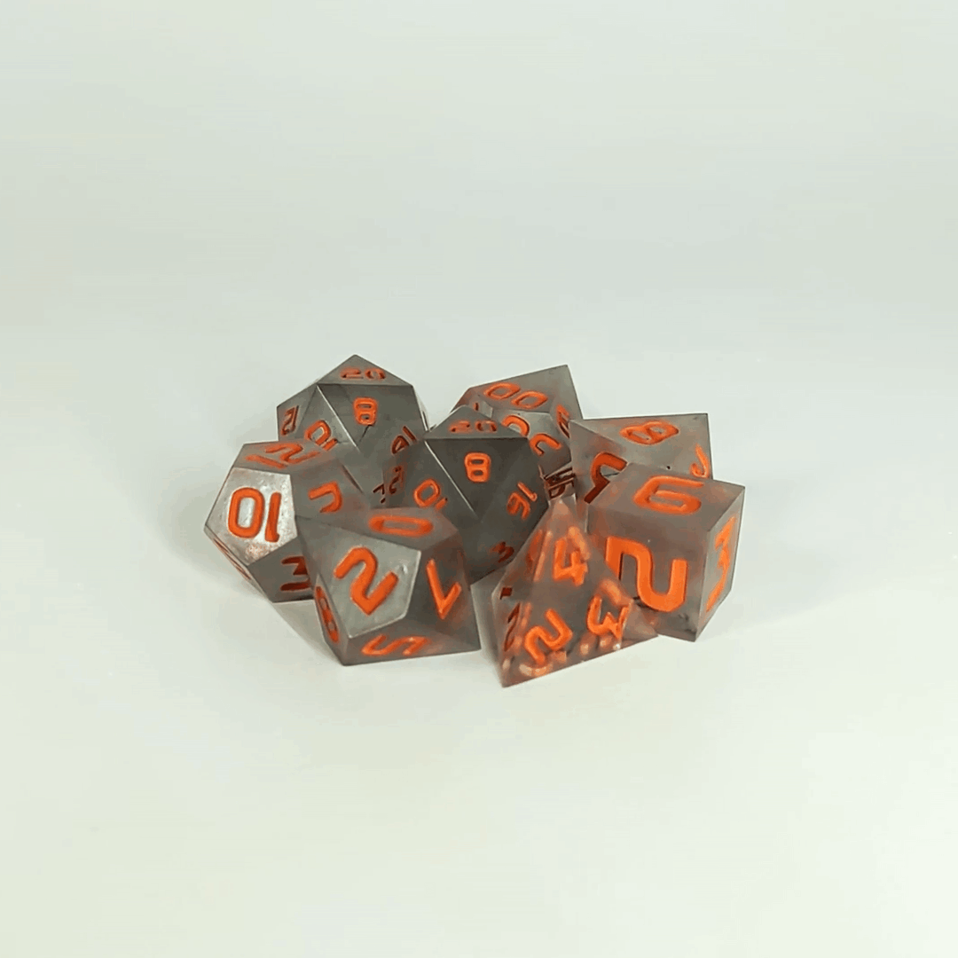 A gif showing the polyhedral dnd dice in a circle with a d20 in the middle surrounded by a standard 7 dice set. The dice have black swirls and orange numbers. The gif transitions from light to darkness and the dice shift from their normal color to glowing green in the dark.