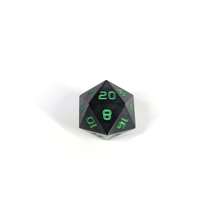 A high angle photo of a standard d20 with black swirls and green numbers with the 20 face up on a white background.