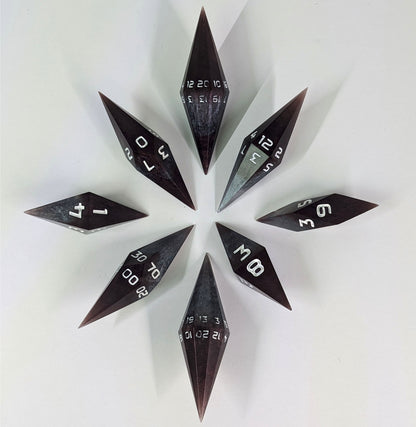 A complete set of diamond shaped resin dice featuring 2 d20s. These handmade dice are deep maroon and dark silver with white numbers and are clustered in a circle with the bottom points angled toward a central point on a white background.