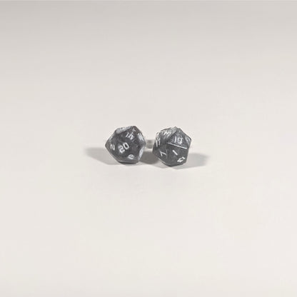 A single pair of the smaller size handmade d20 earrings with titanium hardware that are maroon and dark silver with white numbers on a white background. The earring on the left centers the 20 face and the earring on the right centers the 1 face.