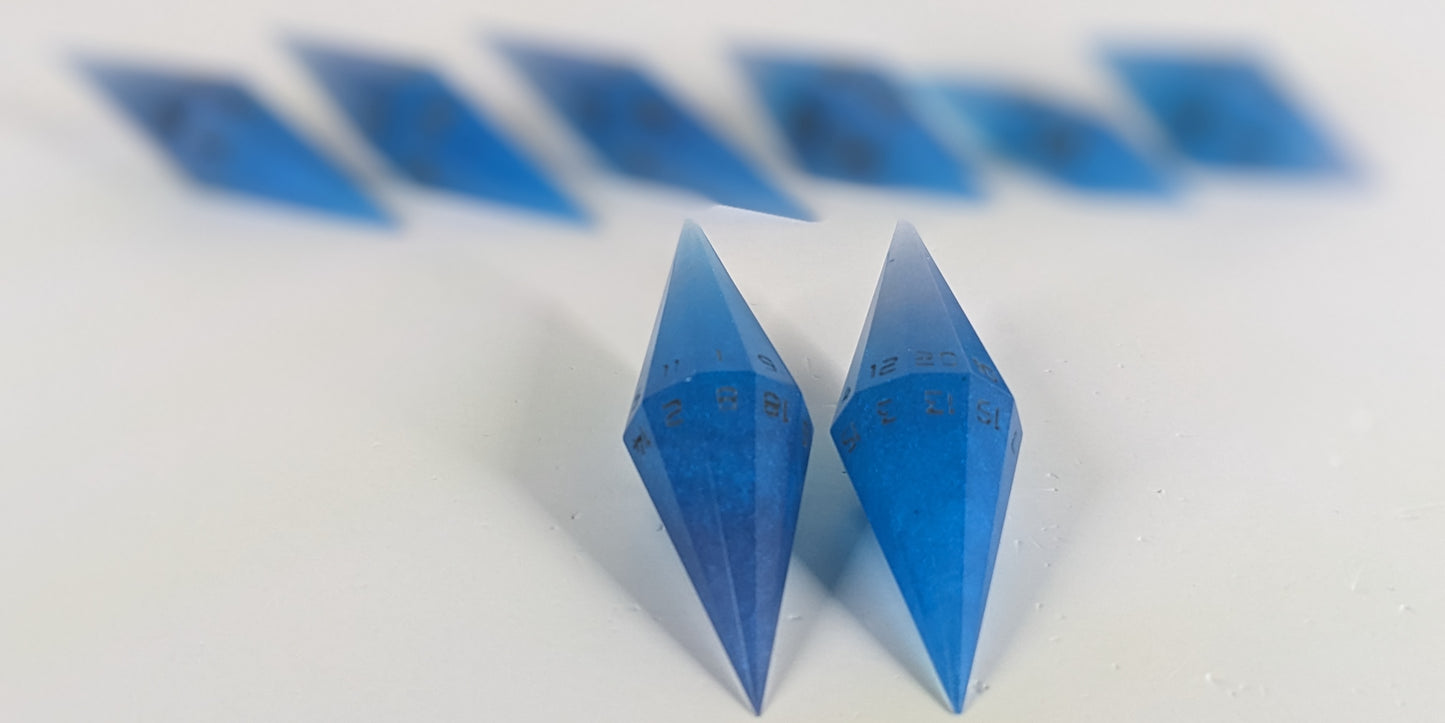 A stylized macro shot focusing heavily on 2 d20s from a Blue: electric blue swirls with grey numbering handmade dice set in the foreground. The sharp diamond edges of these front resin dice are crisp, while the rest of the matching artisan dice collection forms a softly blurred background, creating depth.
