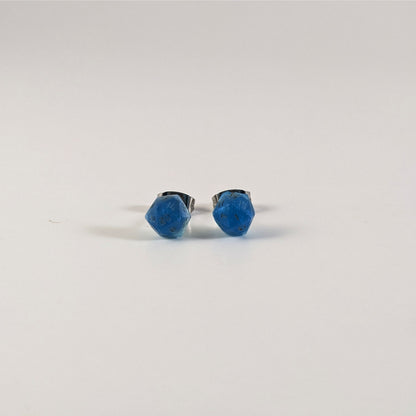 A single pair of the smaller size handmade d20 earrings that are swirls of blue with stormy gray numbers on a white background. The earring on the left centers the 20 face and the earring on the right centers the 1 face.