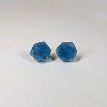 A single pair of the larger size handmade d20 earrings that are swirls of blue with stormy gray numbers on a white background. The earring on the left centers the 20 face and the earring on the right centers the 1 face.