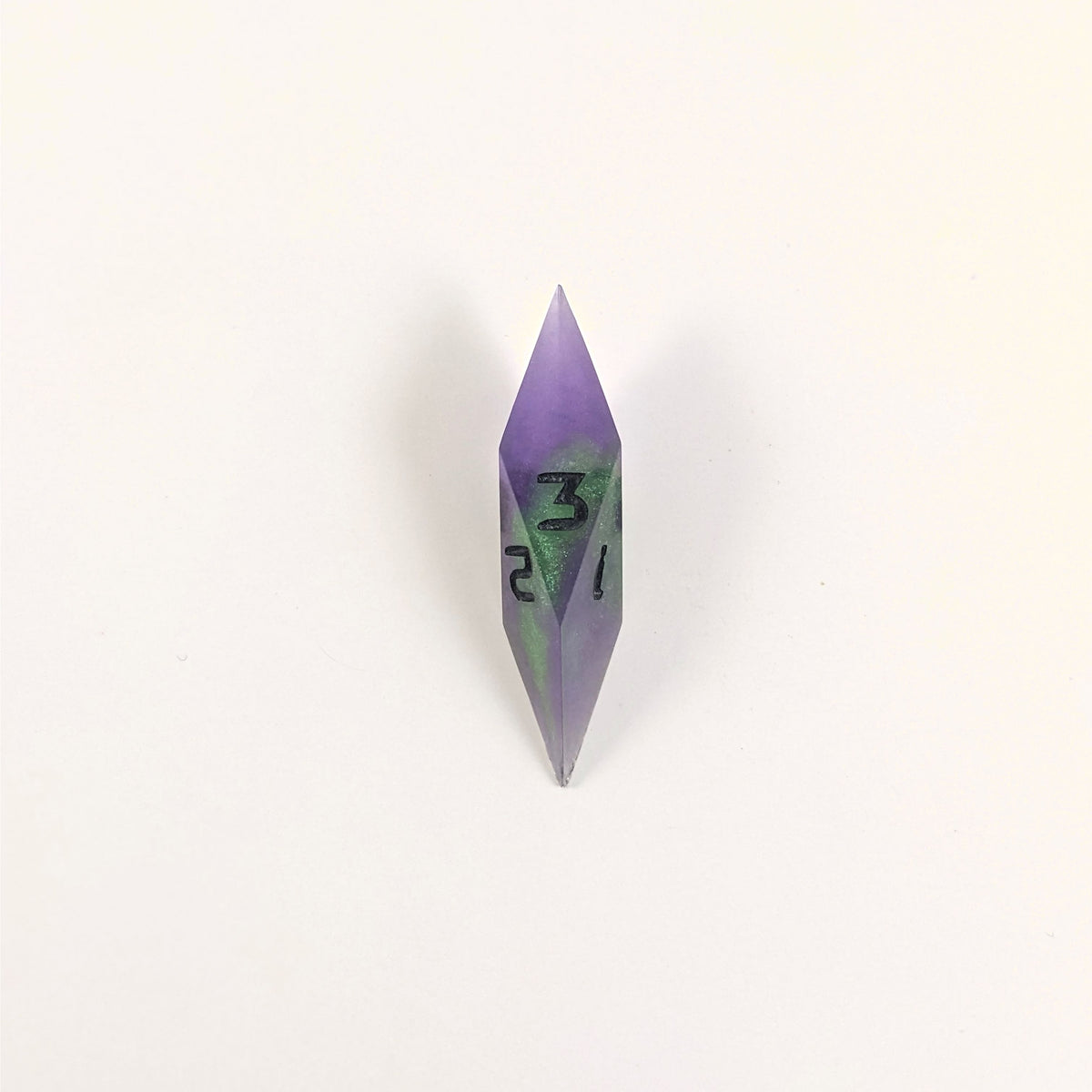A high angle view of a diamond d3 with swirls of purple and green with black numbers that glow in the dark on a white background.