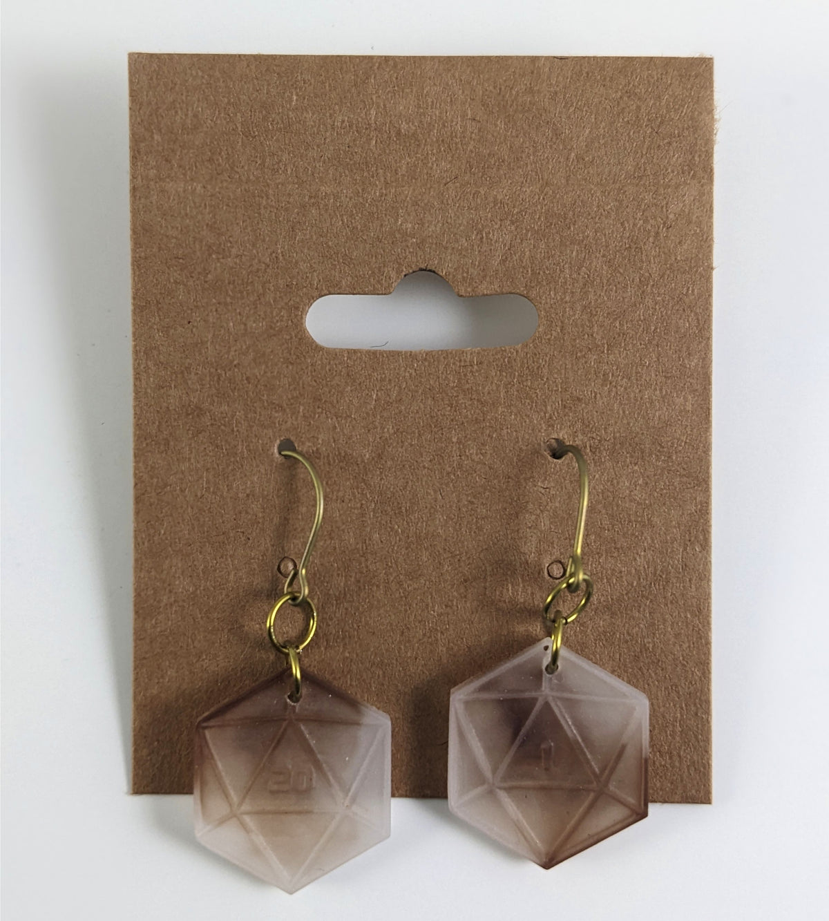 A pair of espresso brown and white dangly, flat d20 earrings with gold color titanium and niobium hardware on a kraft earring card on a white background. The earring on the left has a 20 on it and the earring on the right has a 1 on it, both in a sci-fi style font.