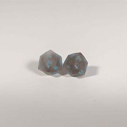 A single pair of the larger size handmade d20 earrings with titanium hardware that are brown and white swirled with teal numbers on a white background. The earring on the left centers the 20 face and the earring on the right centers the 1 face.
