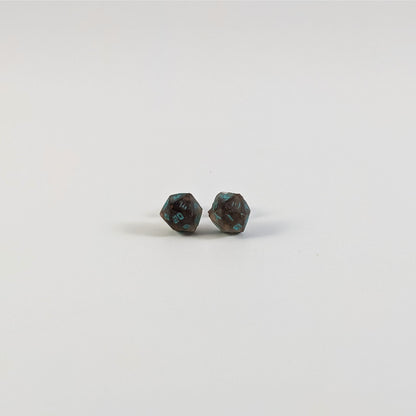 A single pair of the smaller size handmade d20 earrings with titanium hardware that are brown and white swirled with teal numbers on a white background. The earring on the left centers the 20 face and the earring on the right centers the 1 face.