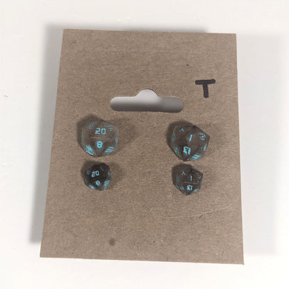 Two pairs of handmade d20 earrings with titanium hardware that are brown and white swirls with teal numbers on a kraft brown earring card with a T in the top right corner. The earrings on the left of each pair centers the 20 face and the earrings on the right of each pair centers the 1 face.