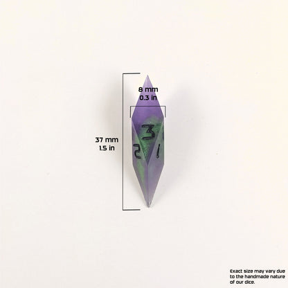 A size graphic of a diamond d3. The die is purple and green with black numbers. The die is 37 mm 1.5 in tall and 8 mm 0.3 in wide. The bottom right corner notes "Exact size may vary due to the handmade nature of our dice."