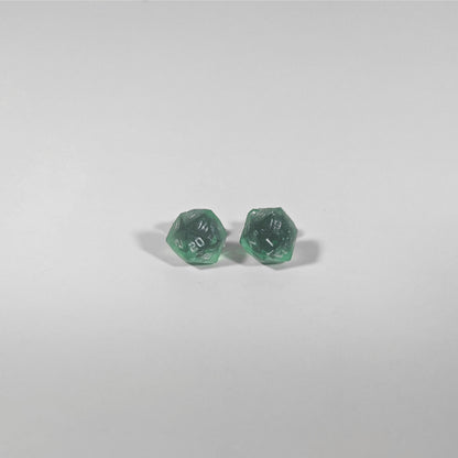 A single pair of the smaller size handmade d20 earrings with titanium hardware that are emerald green with silver numbers on a white background. The earring on the left centers the 20 face and the earring on the right centers the 1 face.