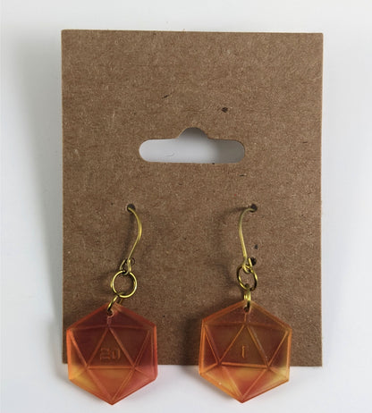 A pair of fiery red and orange dangly, flat d20 earrings with gold color titanium and niobium hardware on a kraft earring card on a white background. The earring on the left has a 20 on it and the earring on the right has a 1 on it, both in a sci-fi style font.