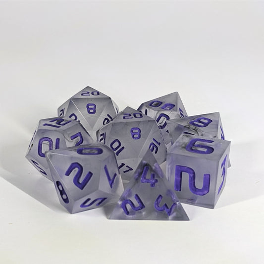 A complete set of 8 handmade artisan dice that have black swirls around a cloudy insert with purple numbers. The DnD dice set is arranged in a circle and features 2 D20s, one of which is in the center surrounded by the other 7 dice.