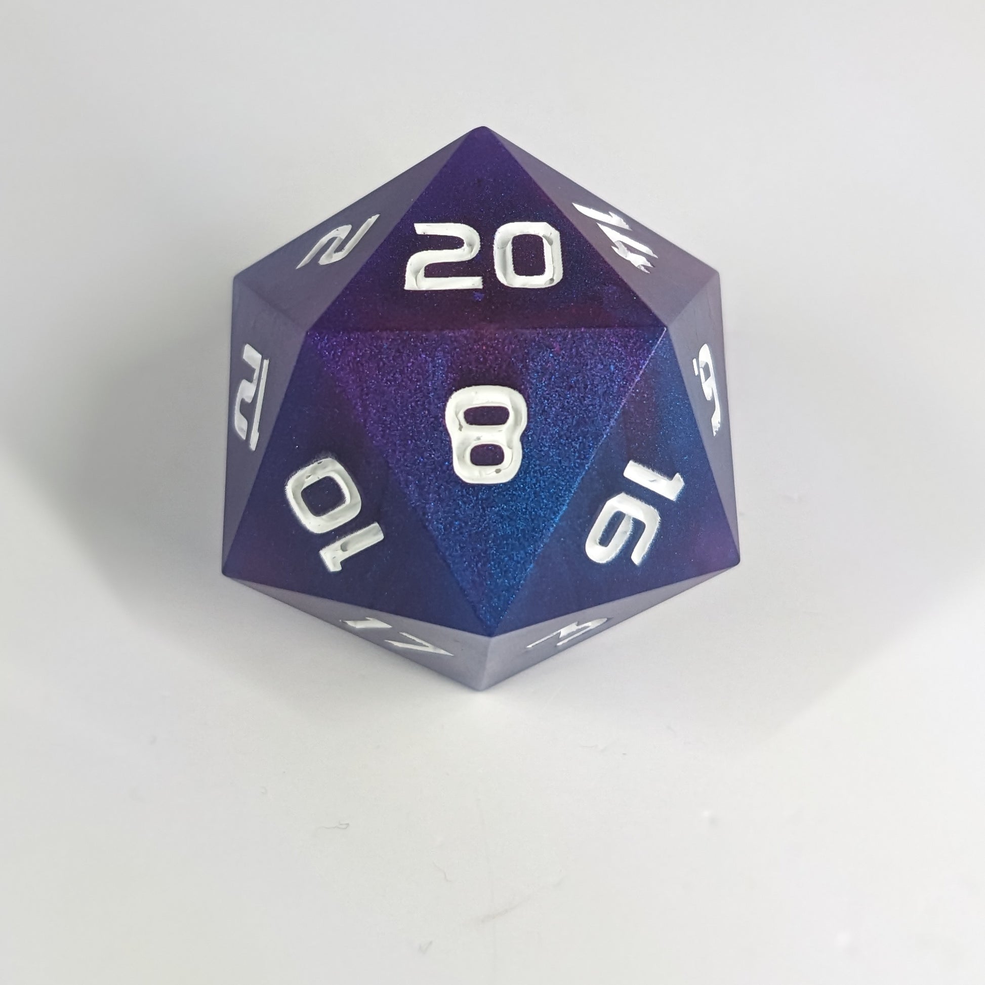 A large d20 that has subtle swirls of purple, blue, and pink with white numbers sits in front of a white background.