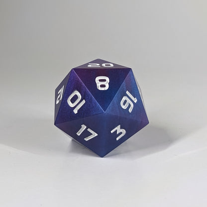 A straight on photo of a large d20 that has subtle swirls of purple, blue, and pink with white numbers on a white background.