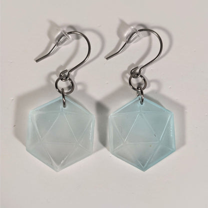 A pair of frosty blue and white dangly, flat d20 earrings with silver color titanium and niobium hardware and bell shaped rubber backs on a white background.