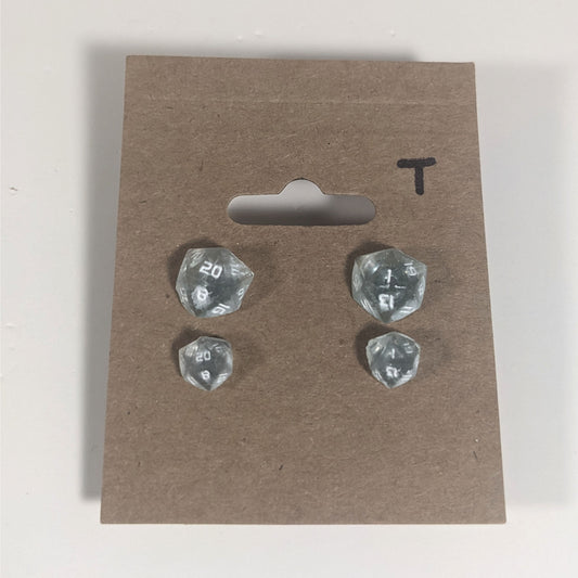 Two pairs of handmade d20 earrings with titanium hardware that are frosty blue and white with white numbers on a kraft brown earring card with a T in the top right corner. The earrings on the left of each pair centers the 20 face and the earrings on the right of each pair centers the 1 face.