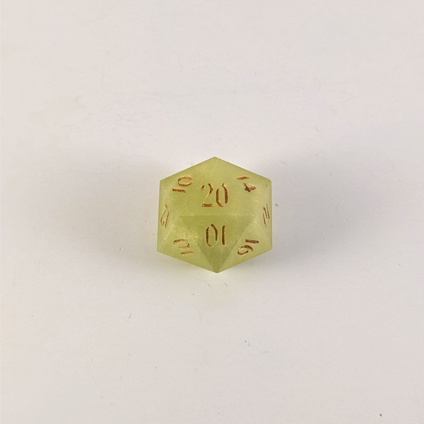 A top down photo of a reliable talent d20 on a white background. The die is light green with gold numbers. Faces that would be 9 or below are replaced with a 10.