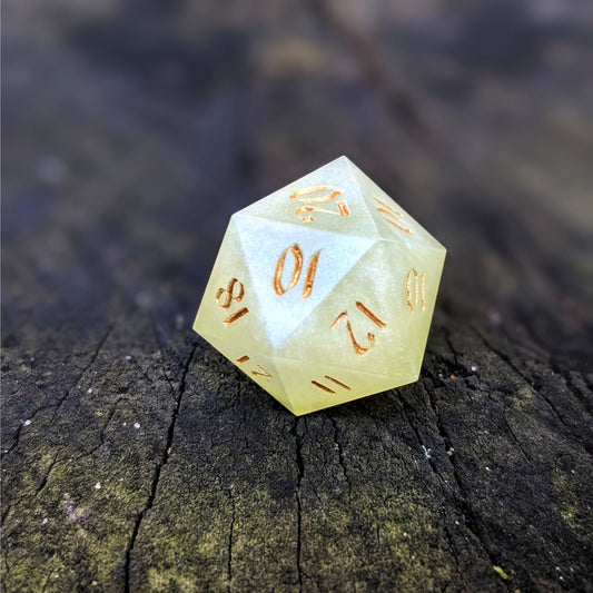 A close up photo of a light green reliable talent d20 with gold numbers sitting on a wood stump. Faces that would be 9 or below are replaced with a 10.
