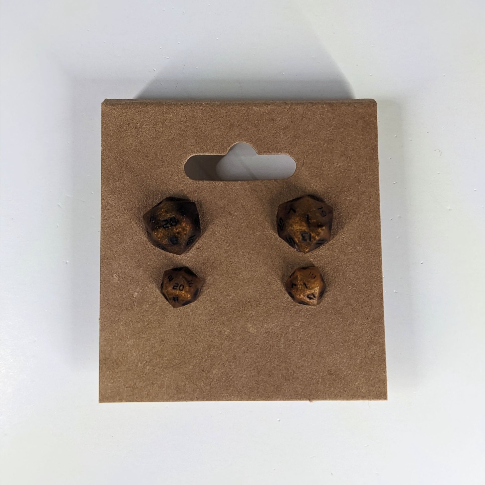 Two pairs of handmade d20 earrings that are orange and deep red with black numbers on a kraft brown earring card. The earrings on the left of each pair centers the 20 face and the earrings on the right of each pair centers the 1 face.