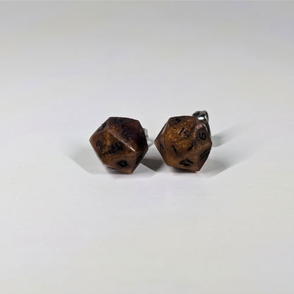 A single pair of the larger size handmade d20 earrings that are orange and deep red with black numbers on a white background. The earring on the left centers the 20 face and the earring on the right centers the 1 face.