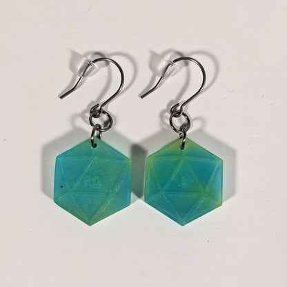 A pair of teal and yellow dangly, flat d20 earrings with silver color titanium and niobium hardware and bell shaped rubber backs on a white background. The earring on the left has a 20 on it and the earring on the right has a 1 on it, both in a sci-fi style font.