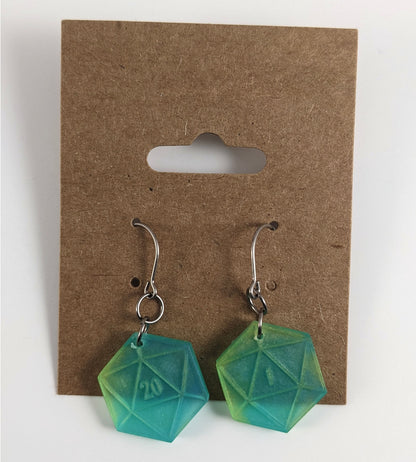 A pair of teal and yellow dangly, flat d20 earrings with silver color titanium and niobium hardware on a kraft earring card on a white background. The earring on the left has a 20 on it and the earring on the right has a 1 on it, both in a fantasy style font.