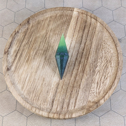 A high angle view of a diamond d20 with swirls of black and green with purple numbers that glow in the dark. It is sitting in the center of a wooden circle.