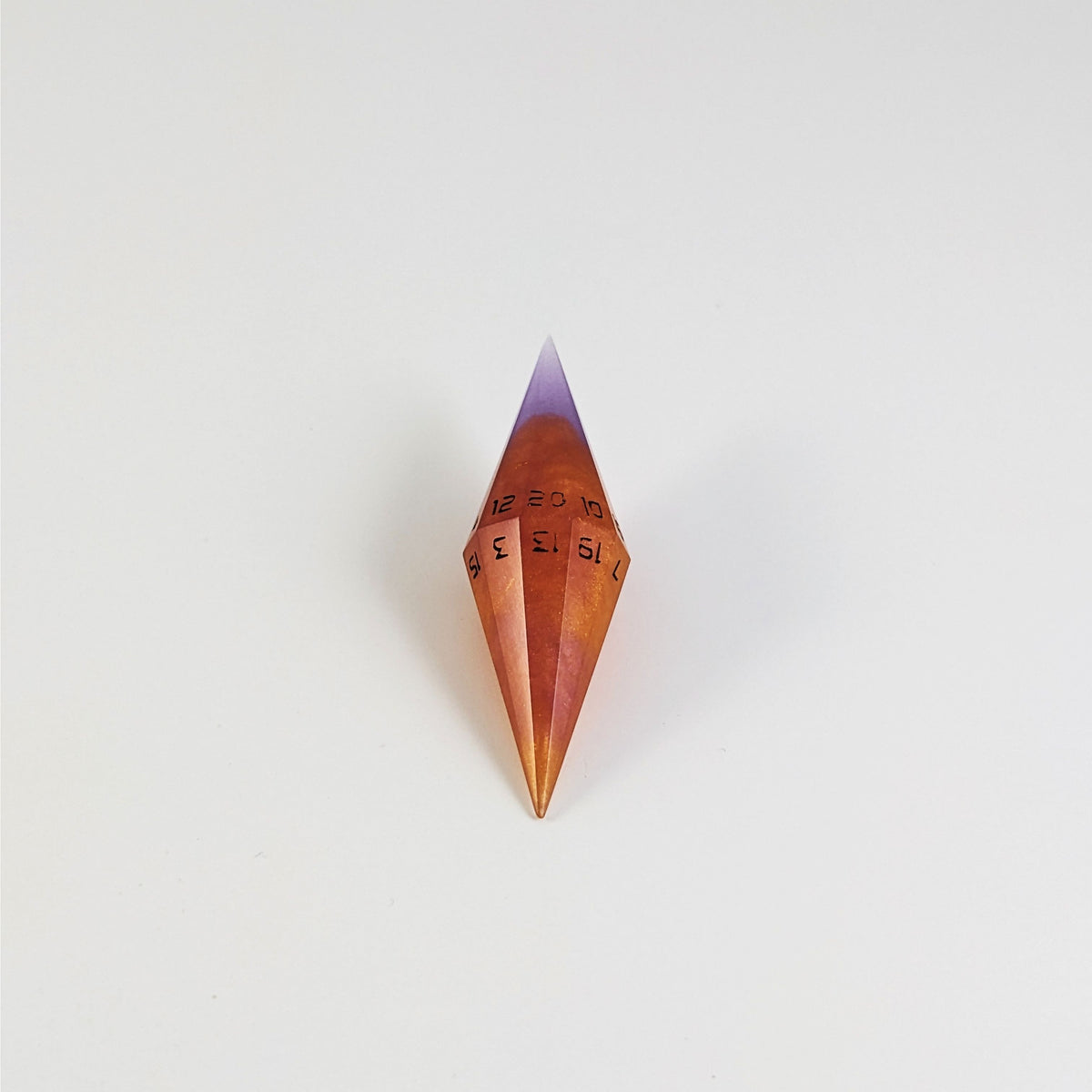 A mid angle shot of a purple and orange diamond d20 with black numbers on a white background.