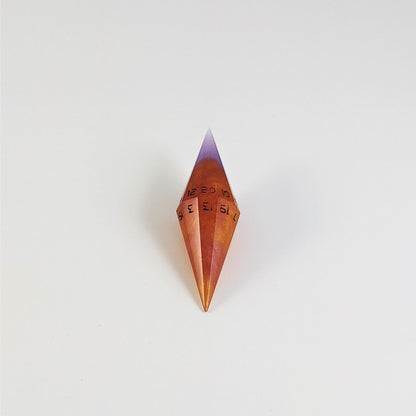 A mid angle shot of a purple and orange diamond d20 with black numbers on a white background.