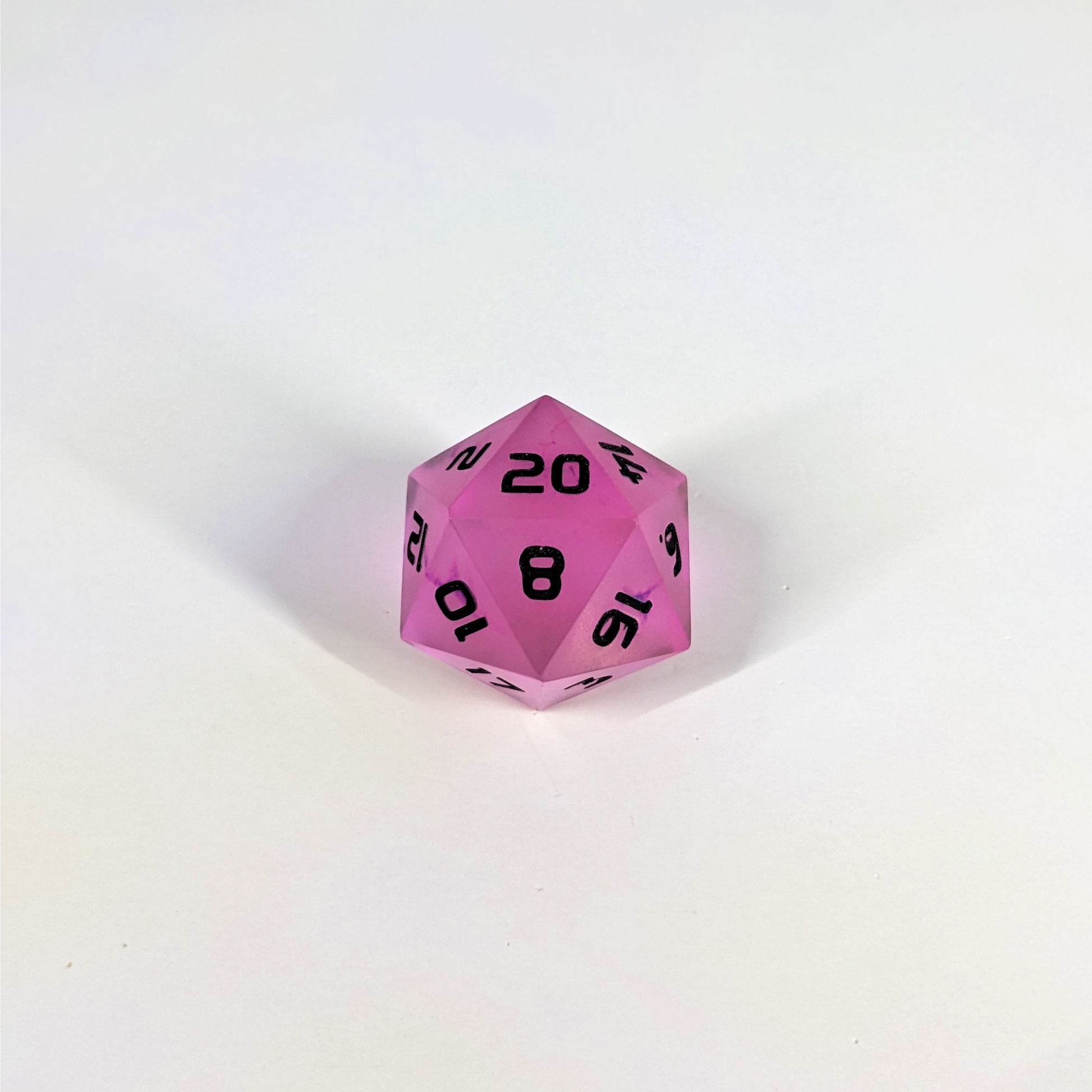 A high angle photo of a standard d20 with pink/purple swirls and black numbers with the 20 face up on a white background.