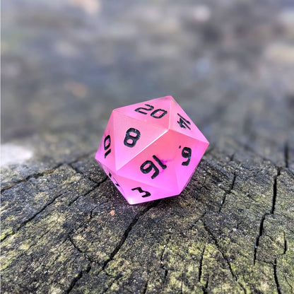 A standard d20 with pink/purple swirls and black numbers sits on a wood stump with the 20 face up.