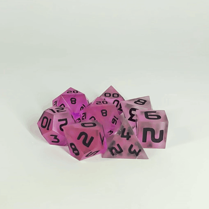 A gif showing the polyhedral dnd dice in a circle with a d20 in the middle surrounded by a standard 7 dice set. The dice have pink/purple swirls and black numbers. The gif transitions from light to darkness and the dice shift from their normal color to glowing green in the dark.