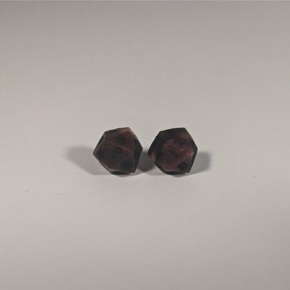 A single pair of the larger size handmade d20 earrings with titanium hardware that are swirls of red with black numbers on a white background. The earring on the left centers the 20 face and the earring on the right centers the 1 face.
