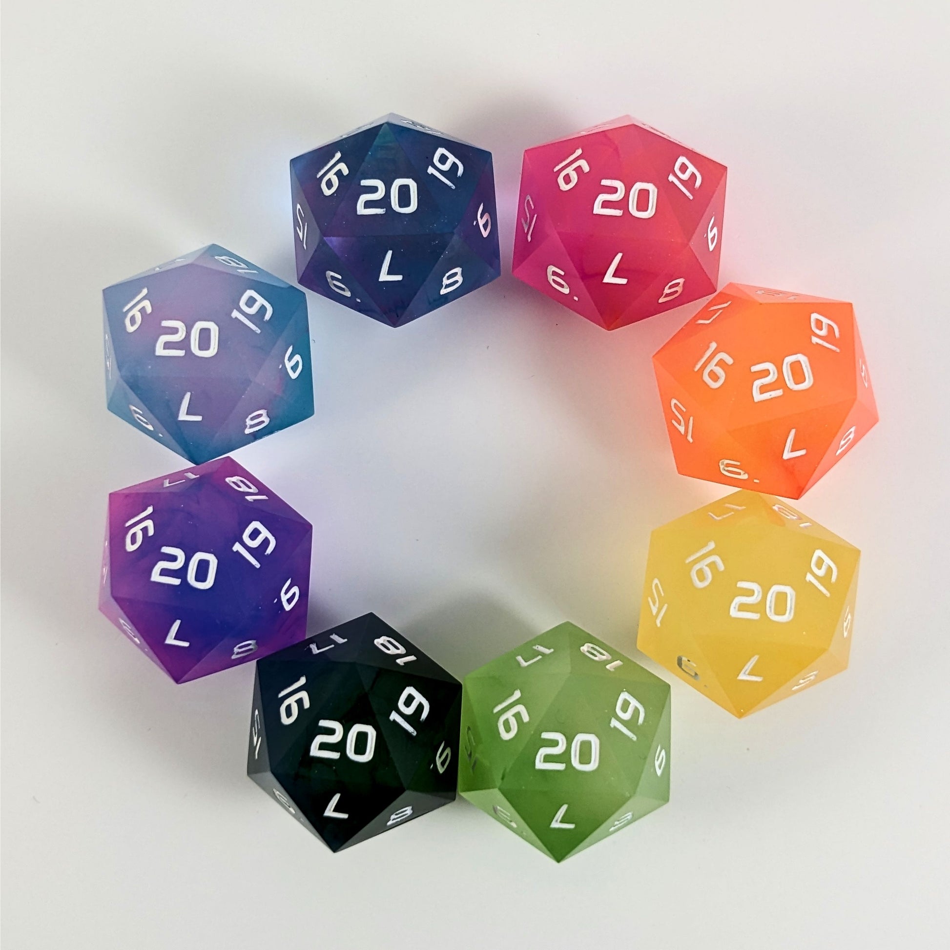 Eight brightly colored spindown d20s with a right spin arranged in a circle on a white background. The top right d20 is magenta, and following clockwise is orange, yellow, yellow green, blue and green, pink and blue, opaque pink and teal, and clear pink and teal.