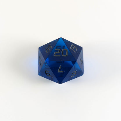 A blue spindown d20 with gray numbers and a right spin sits on a white background with the 20 face up.