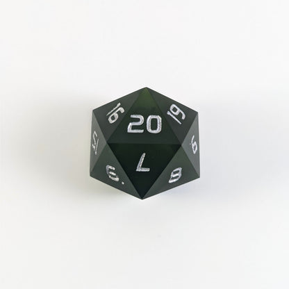 A dark green spindown d20 with silver numbers and a right spin sits on a white background with the 20 face up.