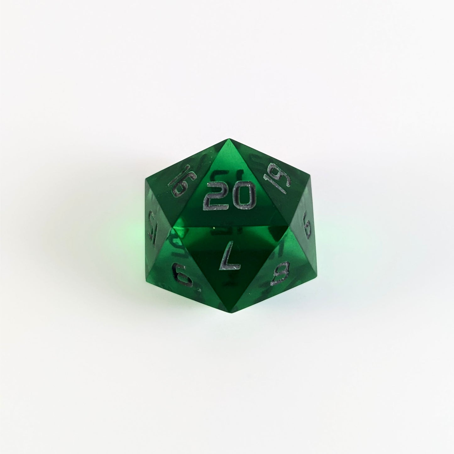 A green spindown d20 with gray numbers and a right spin sits on a white background with the 20 face up.