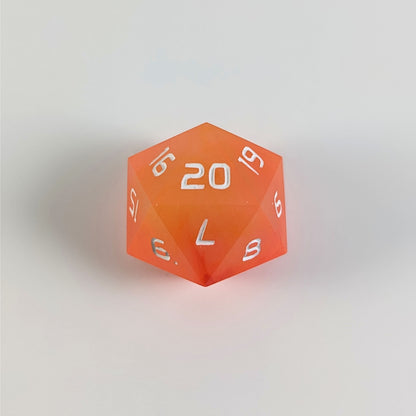 An orange spindown d20 with white numbers and a right spin sits on a white background with the 20 face up.
