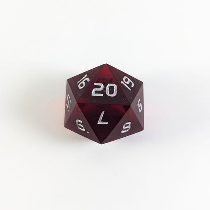 A red spindown d20 with silver numbers and a right spin sits on a white background with the 20 face up.